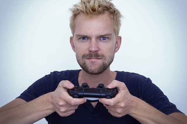 Hráč drží PS4 ovládač.jpg